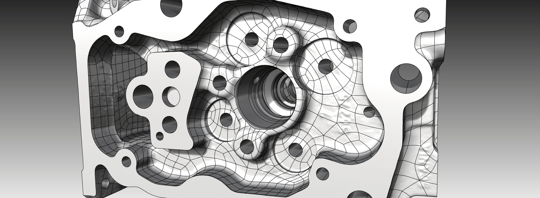Die Darstellung zeigt das Hybrid-CAD-Modell eines Zylinderkopfs. Die Gussflächen werden als Freiformflächen und die bearbeiteten Flächen als Konstruktionsflächen dargestellt.
